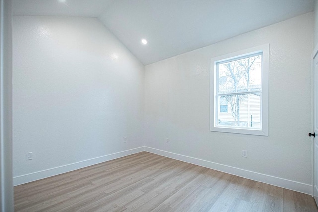 unfurnished room featuring vaulted ceiling and light hardwood / wood-style flooring