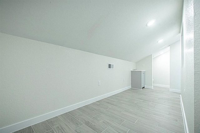 additional living space featuring lofted ceiling