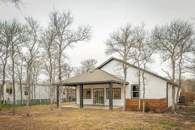 rear view of property with a lawn, a patio area, and central air condition unit