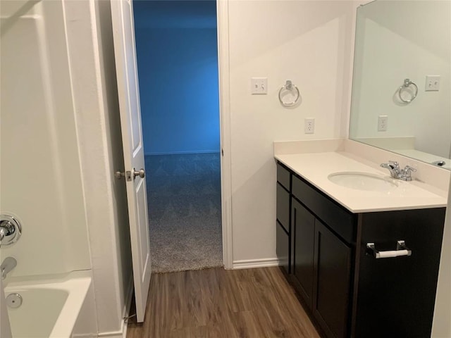 bathroom featuring vanity, hardwood / wood-style flooring, and tub / shower combination