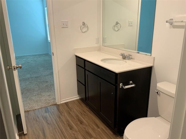 bathroom featuring vanity, wood-type flooring, and toilet