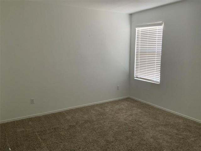 spare room featuring dark carpet