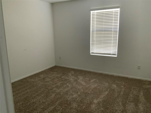 carpeted spare room featuring a healthy amount of sunlight