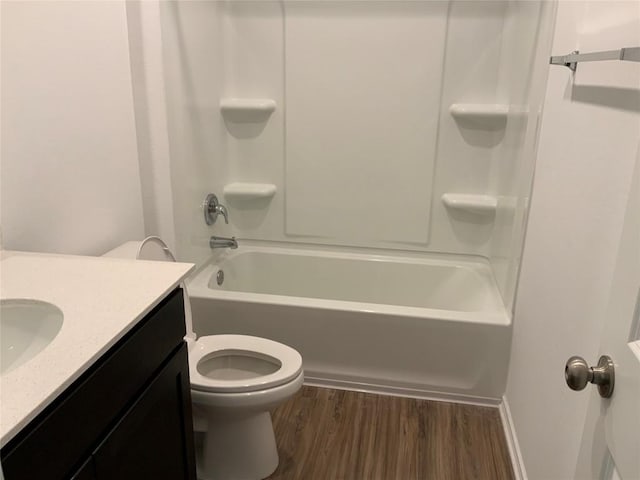 full bathroom featuring washtub / shower combination, wood-type flooring, toilet, and vanity