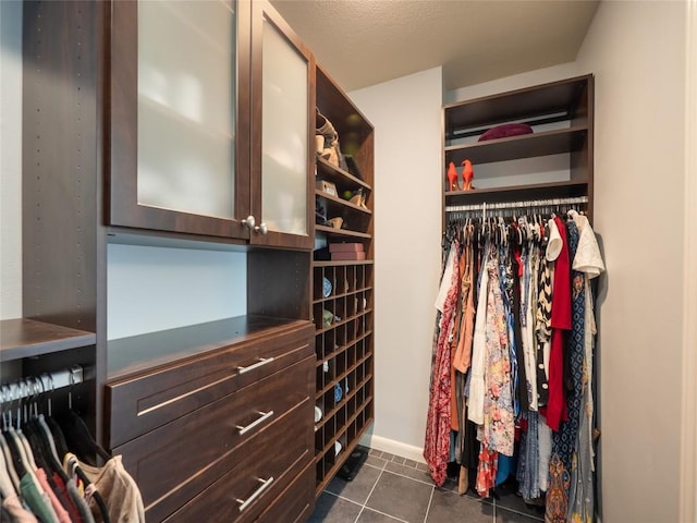 walk in closet with dark tile patterned flooring