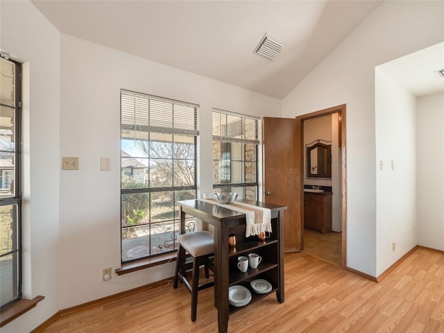 dining space with lofted ceiling and light wood-type flooring