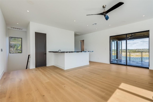 unfurnished living room with ceiling fan and light hardwood / wood-style floors