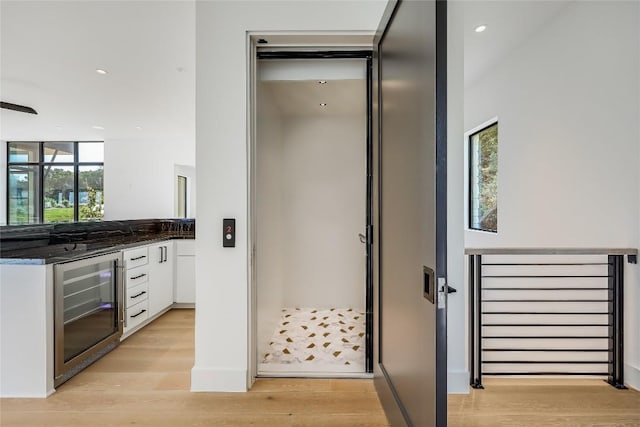 interior space with wine cooler and hardwood / wood-style flooring