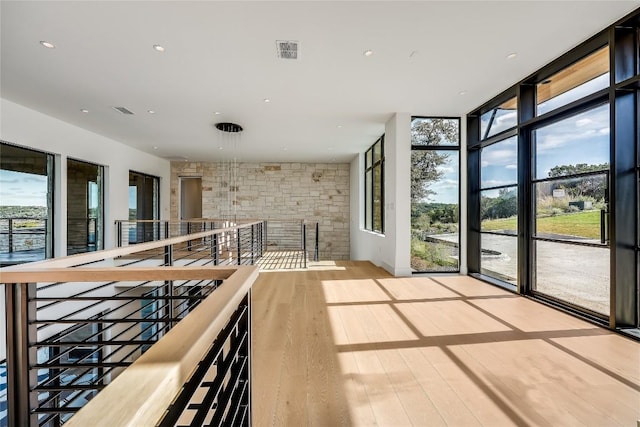 interior space featuring floor to ceiling windows, plenty of natural light, and light hardwood / wood-style flooring