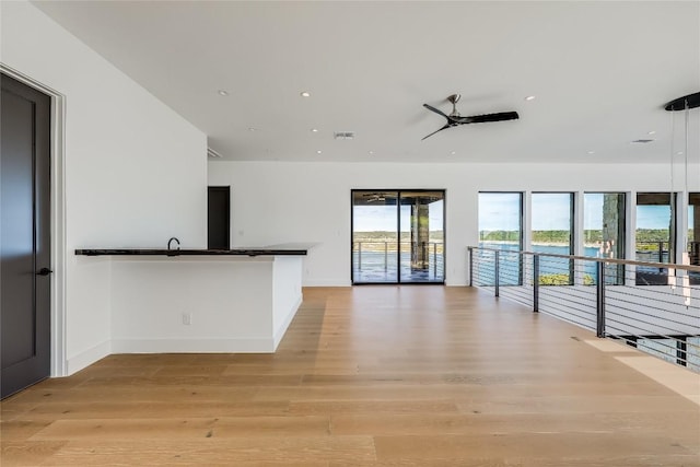 unfurnished living room featuring ceiling fan and light hardwood / wood-style flooring