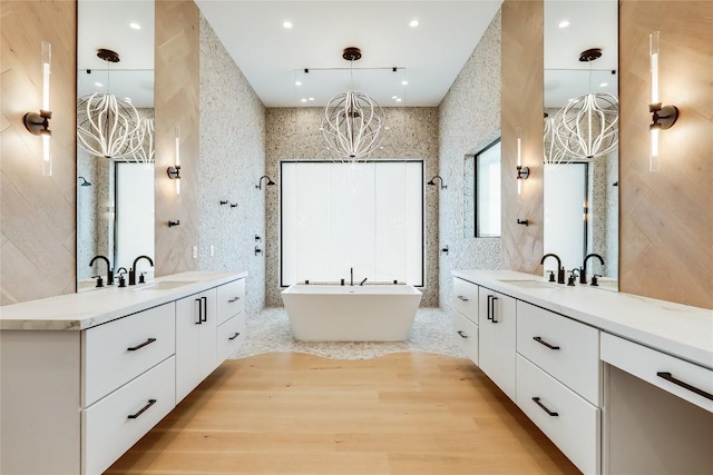 bathroom with vanity, tile walls, and a tub to relax in