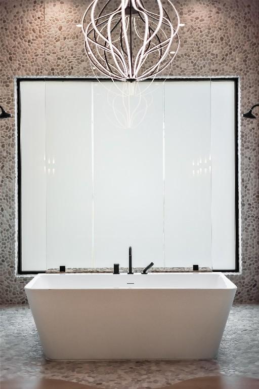 bathroom with concrete flooring and a washtub