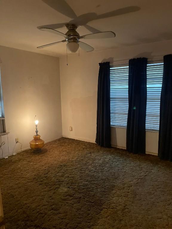 spare room with ceiling fan and carpet