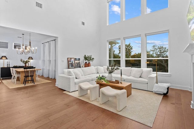 living area featuring hardwood / wood-style floors, visible vents, and a notable chandelier