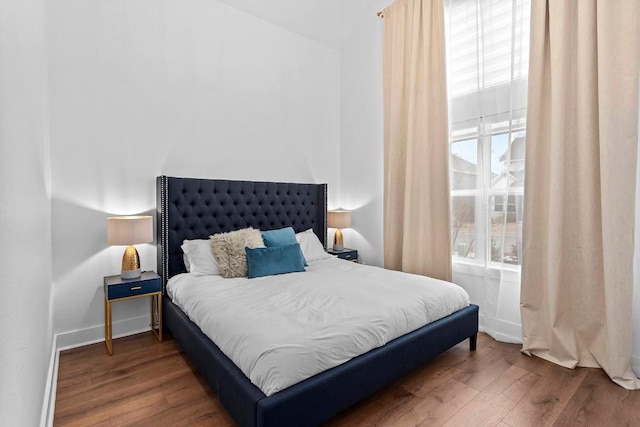 bedroom with baseboards and wood finished floors