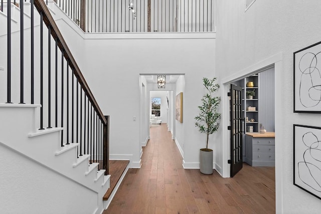 entrance foyer featuring wood-type flooring and a high ceiling