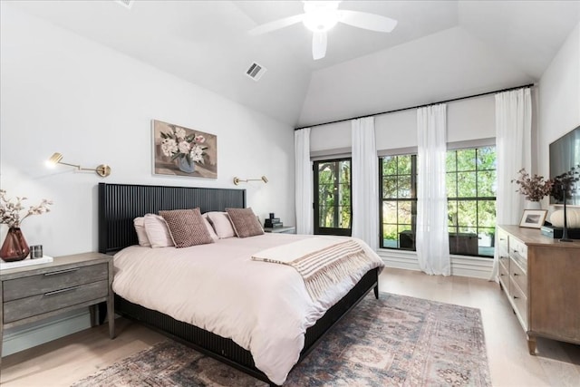 bedroom with multiple windows, wood-type flooring, and lofted ceiling