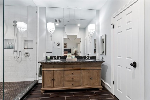 bathroom with tiled shower and vanity