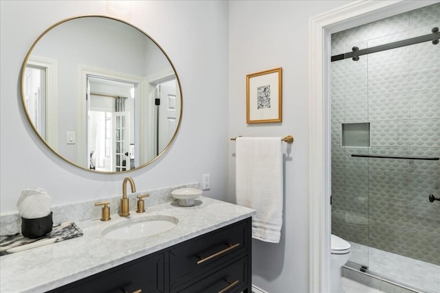 bathroom featuring vanity, an enclosed shower, and toilet