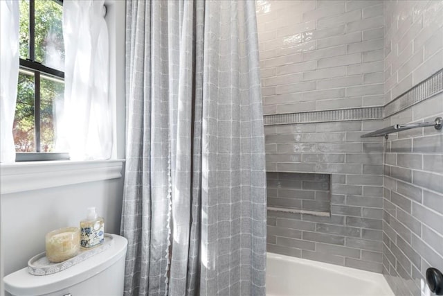 bathroom with shower / bath combination with curtain and toilet