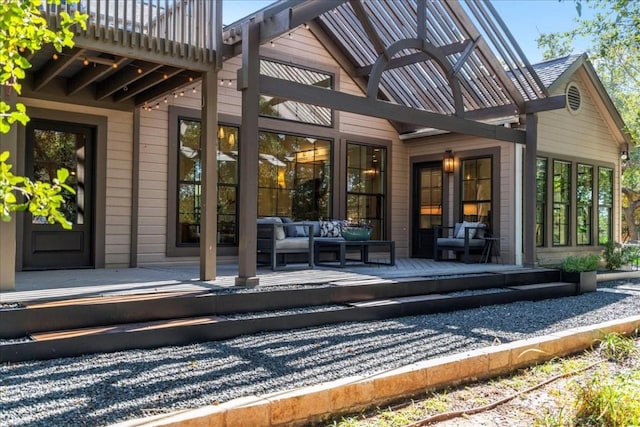 rear view of property with a wooden deck and outdoor lounge area