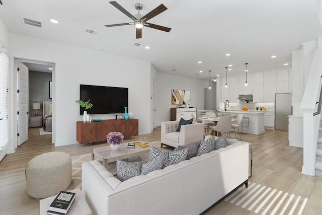 living room with ceiling fan and light hardwood / wood-style floors