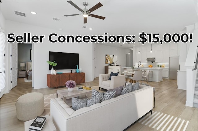 living area with light wood-style flooring, visible vents, ceiling fan, and recessed lighting