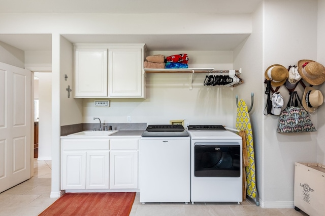 clothes washing area with cabinets, light tile patterned flooring, sink, and washer and clothes dryer