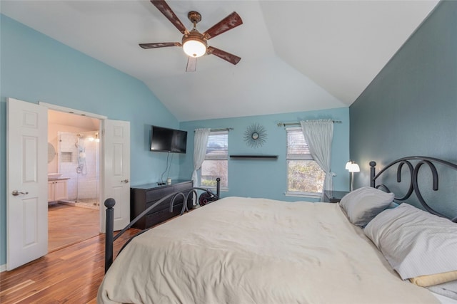 bedroom featuring hardwood / wood-style floors, ensuite bath, vaulted ceiling, and ceiling fan