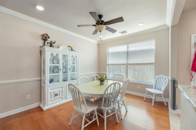 dining space featuring ornamental molding, ceiling fan, and light hardwood / wood-style floors