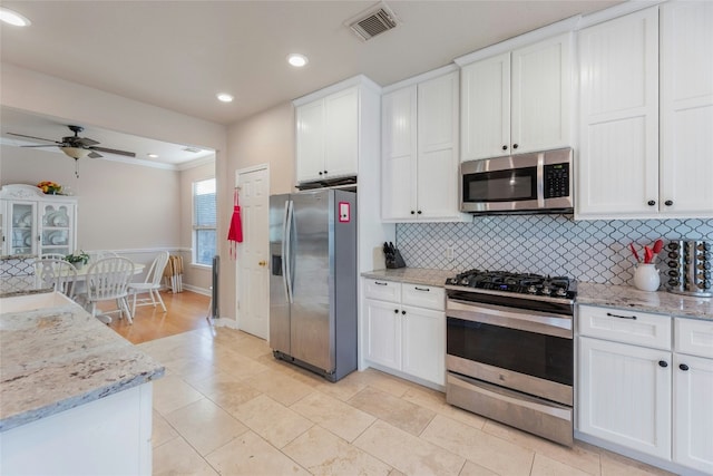 16805 Willow Oak Ln, Round Rock, TX 78681 - kitchen featuring stainless steel appliances, decorative backsplash, white cabinetry, recessed lighting, and light stone counters