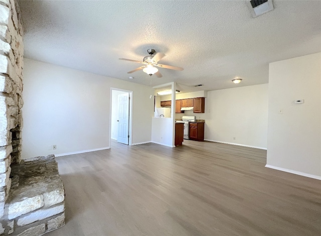 unfurnished living room with ceiling fan, dark hardwood / wood-style floors, and a textured ceiling