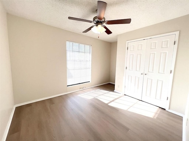 unfurnished bedroom with ceiling fan, a closet, light hardwood / wood-style flooring, and a textured ceiling