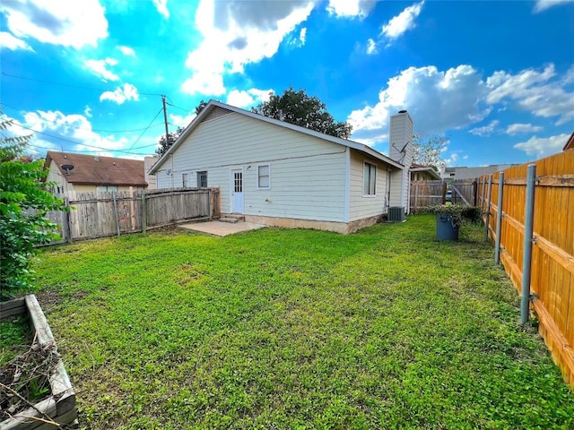 back of house with central AC, a yard, and a patio area