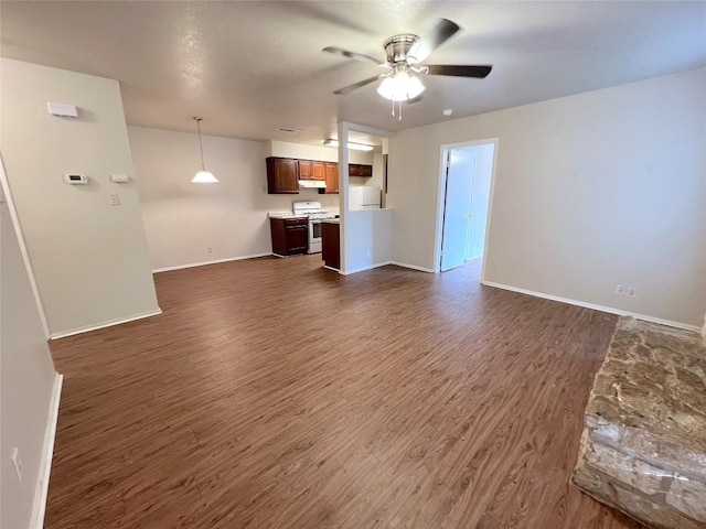 unfurnished living room with dark wood-type flooring and ceiling fan