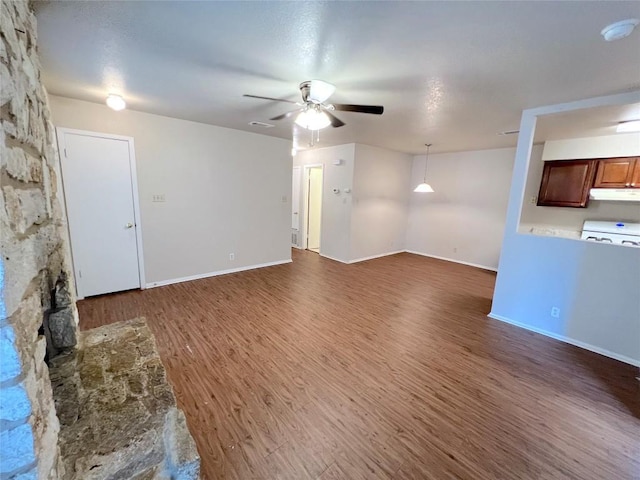 unfurnished living room with dark hardwood / wood-style flooring and ceiling fan