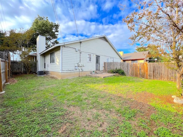 back of property featuring cooling unit and a yard