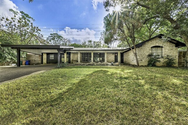 view of front of home with a front yard and a carport