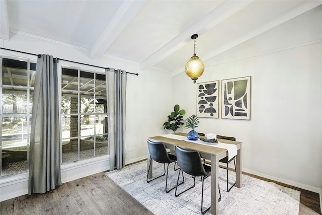 dining room with wood-type flooring and vaulted ceiling with beams