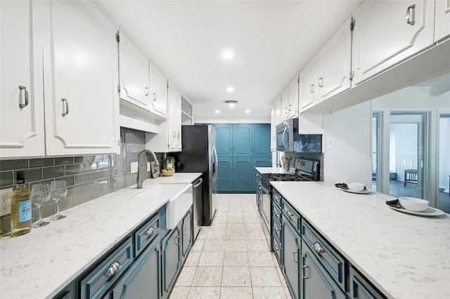 kitchen featuring sink, white cabinetry, stainless steel appliances, tasteful backsplash, and blue cabinets