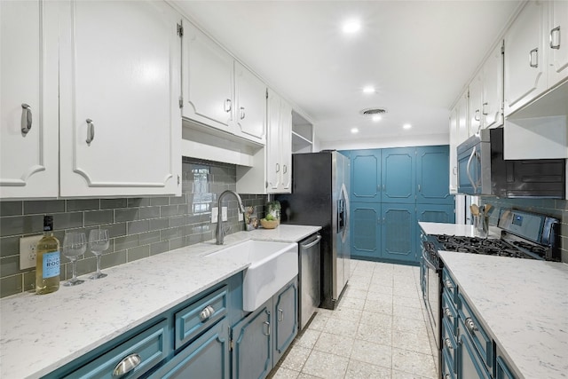 kitchen with sink, blue cabinetry, stainless steel appliances, white cabinets, and decorative backsplash