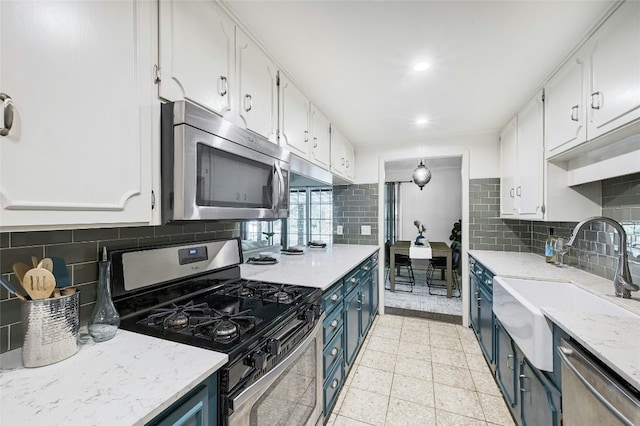 kitchen featuring stainless steel appliances, blue cabinets, sink, and white cabinets