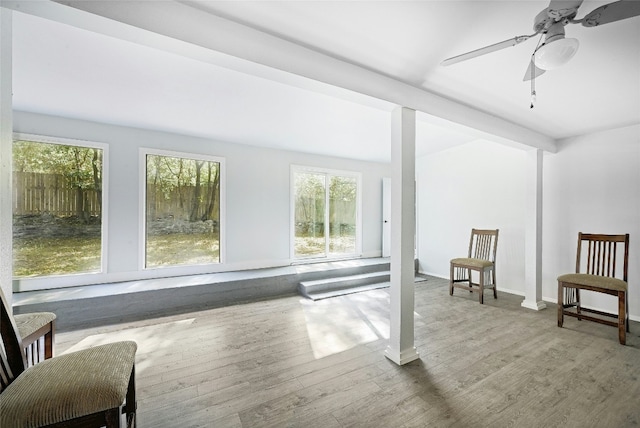 interior space with hardwood / wood-style flooring, ceiling fan, and beam ceiling