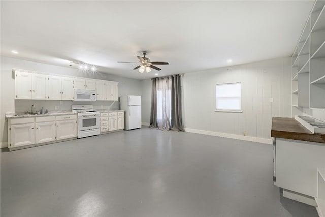 kitchen with concrete flooring, white cabinetry, sink, and white appliances