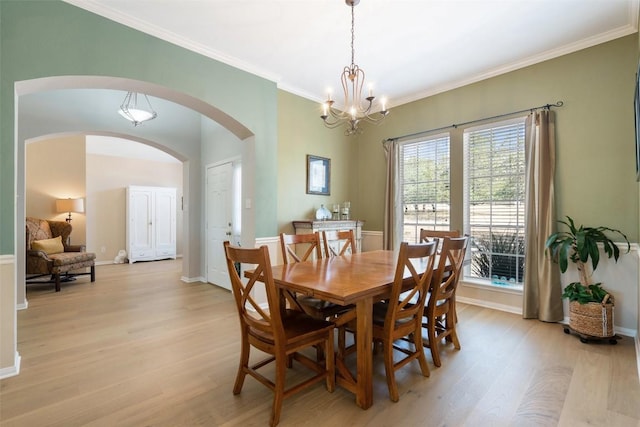 dining area featuring light wood-type flooring, a chandelier, and ornamental molding