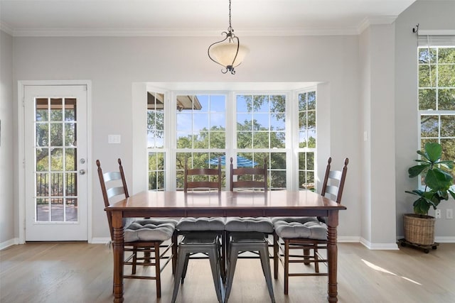 dining space with ornamental molding and light wood-type flooring