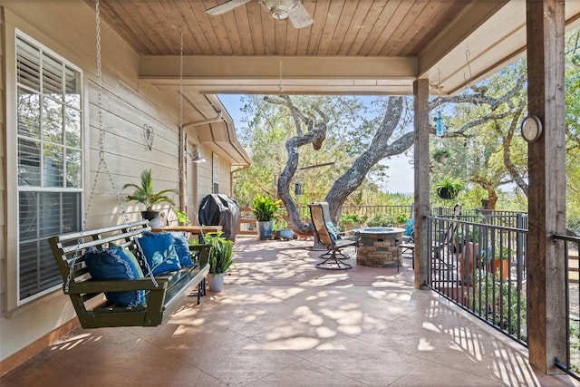 exterior space featuring area for grilling, an outdoor living space with a fire pit, and ceiling fan