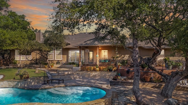 pool at dusk with a patio