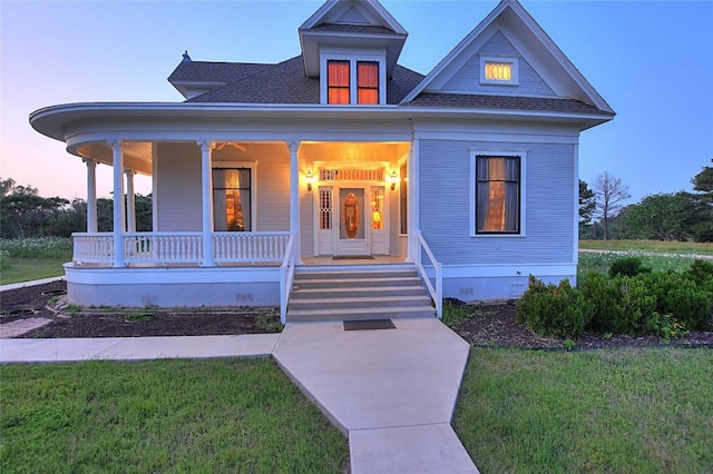 view of front of property featuring covered porch and a lawn