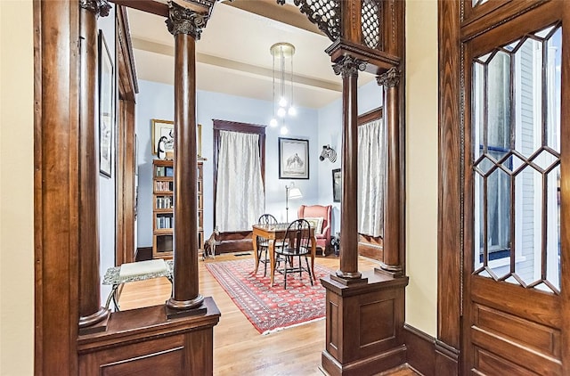 foyer entrance featuring decorative columns and light wood-type flooring